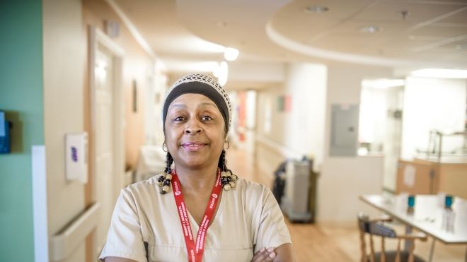 A back women health care worker at Northwood LTC standing with her arms folded.