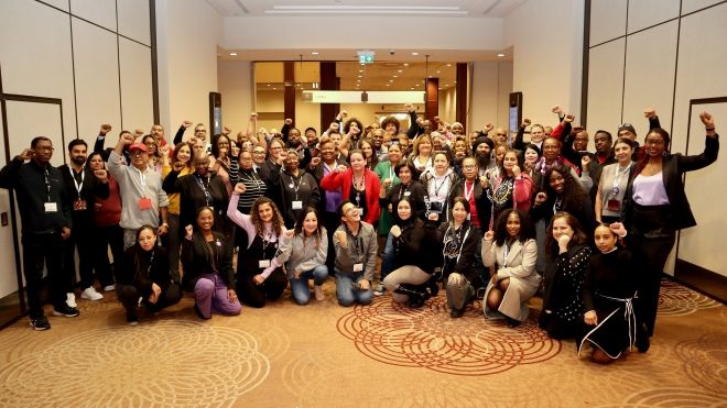 A large group of people posing fists raised 