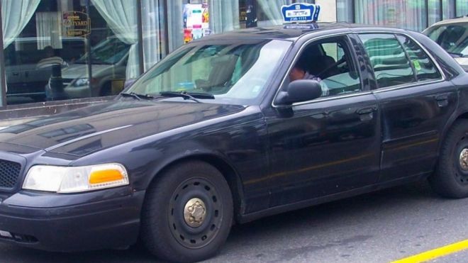 A dark coloured Ottawa taxi.