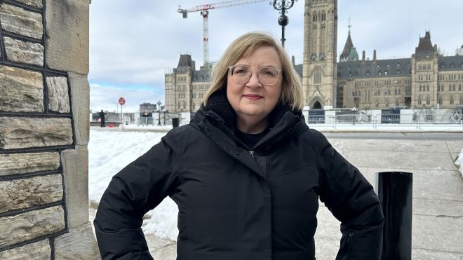 Lana Payne hands on hips outside the Parliament Hill