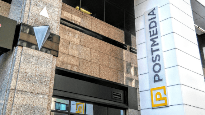 Postmedia yellow and black logo on a white pillar at the building front.