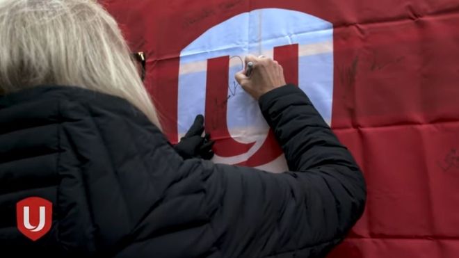A women signing a large Unifor sign 
