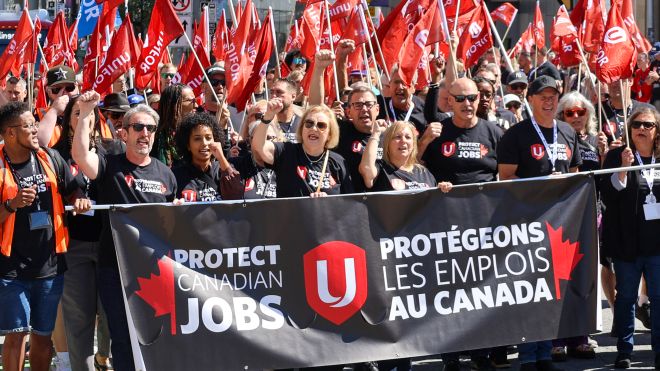 Unifor Protect Canadian Jobs rally a crowd behind a large banner