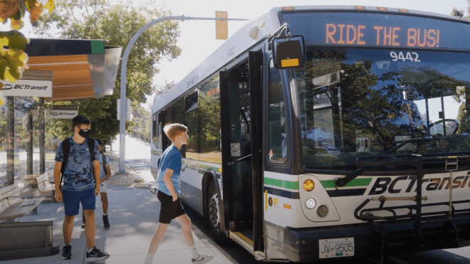 Two young people boarding a BC Transit bus