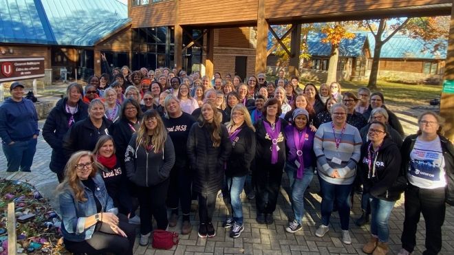 A large group of women posing outside the classrooms at the Unifor Education Centre on a sunny fall day.