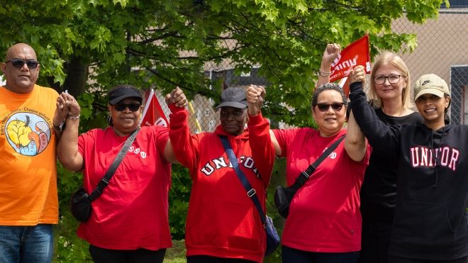 Six people holding hands wareing Unifor shirts