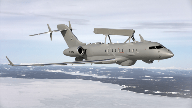 A globa l6500 saab plane flying over water with land in the background