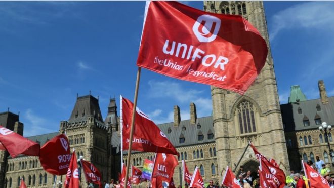 Unifor flags fly in front of the Peace Tower on Parliment Hill in Ottawa.