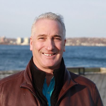Scott Doherty stands in front of boardwalk with ocean in background