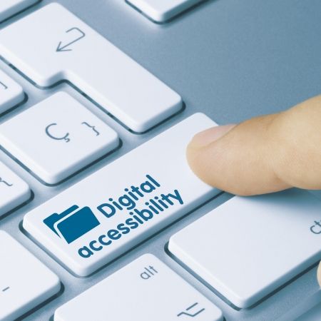 a finger presses on a keyboard with words digital accessibility