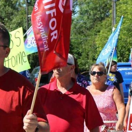 Des membres d'Unifor marchent sur un piquet de grève.