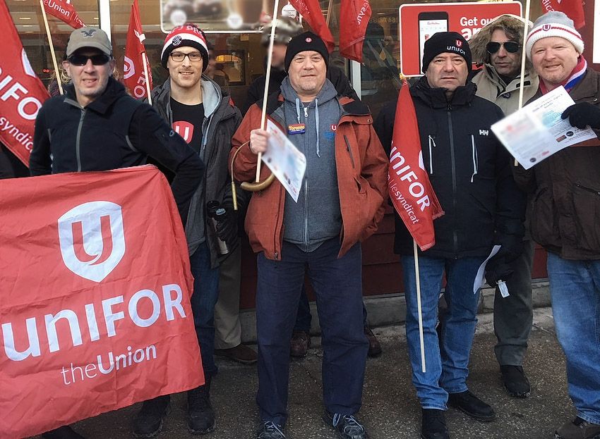 Members of Local 723M hold Unifor flags.