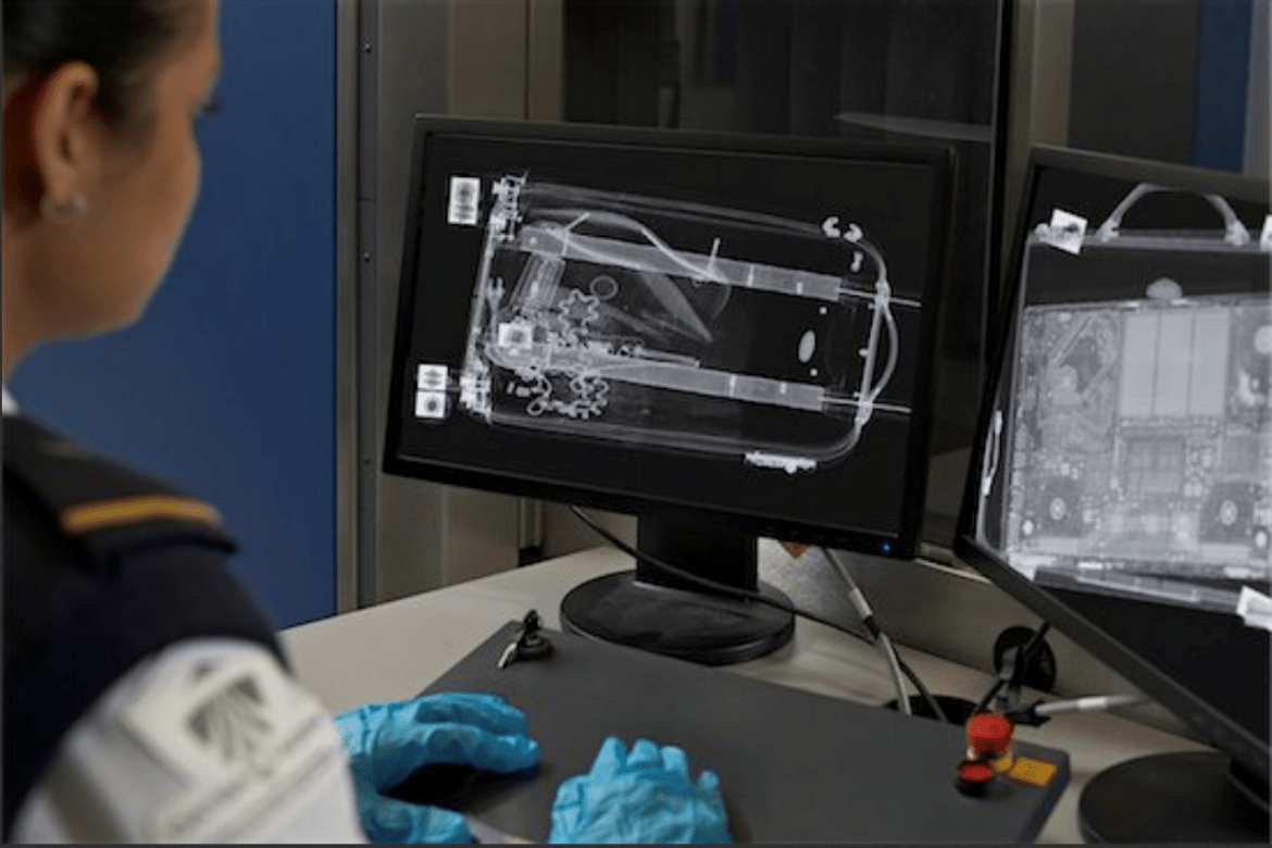 Une agente de contrôle de l'aéroport examine des images radiologiques de bagages.