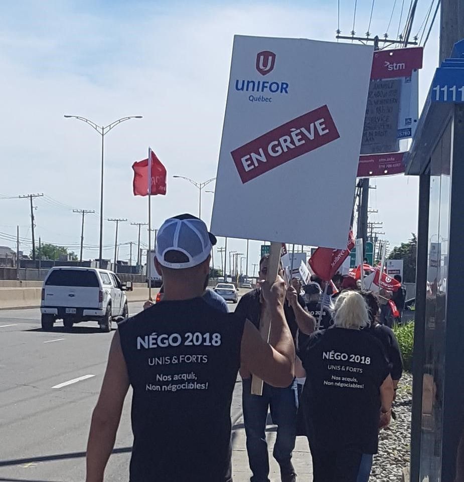 Des membres de la section 522 marchent sur un piquet de grève avec des chemises de baroudeur identiques.