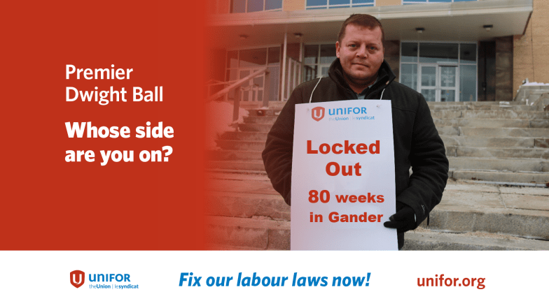 A member of Local 597 wears a sign reading &quot;Locked out 80 wees in Gander&quot; next to the text &quot;Premier Dwight Ball, whose side are yu on?&quot;