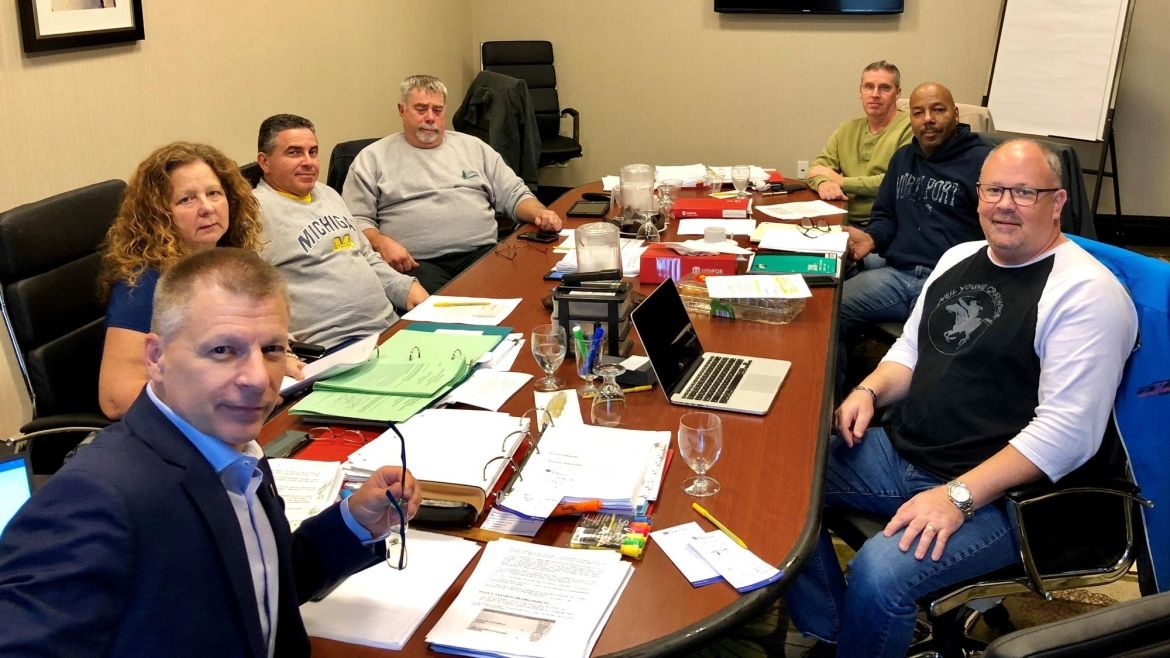 Members of Local 222 working at Durham Region Transit sit around a conference table.