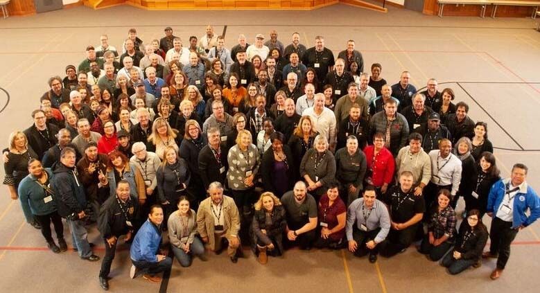 A lagre group of Unifor activists seen from above in a gym.