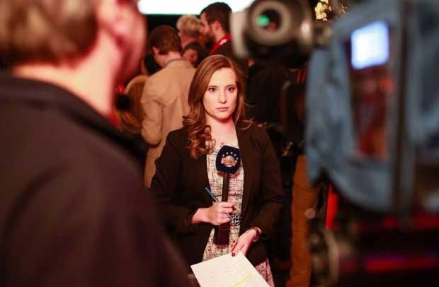 Unifor 915M Heather Gillis reports the news for NTV from a crowded room.