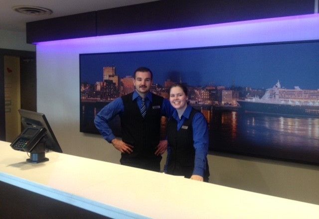Two Unifor members working at the check-in desk of Saint John Hilton.