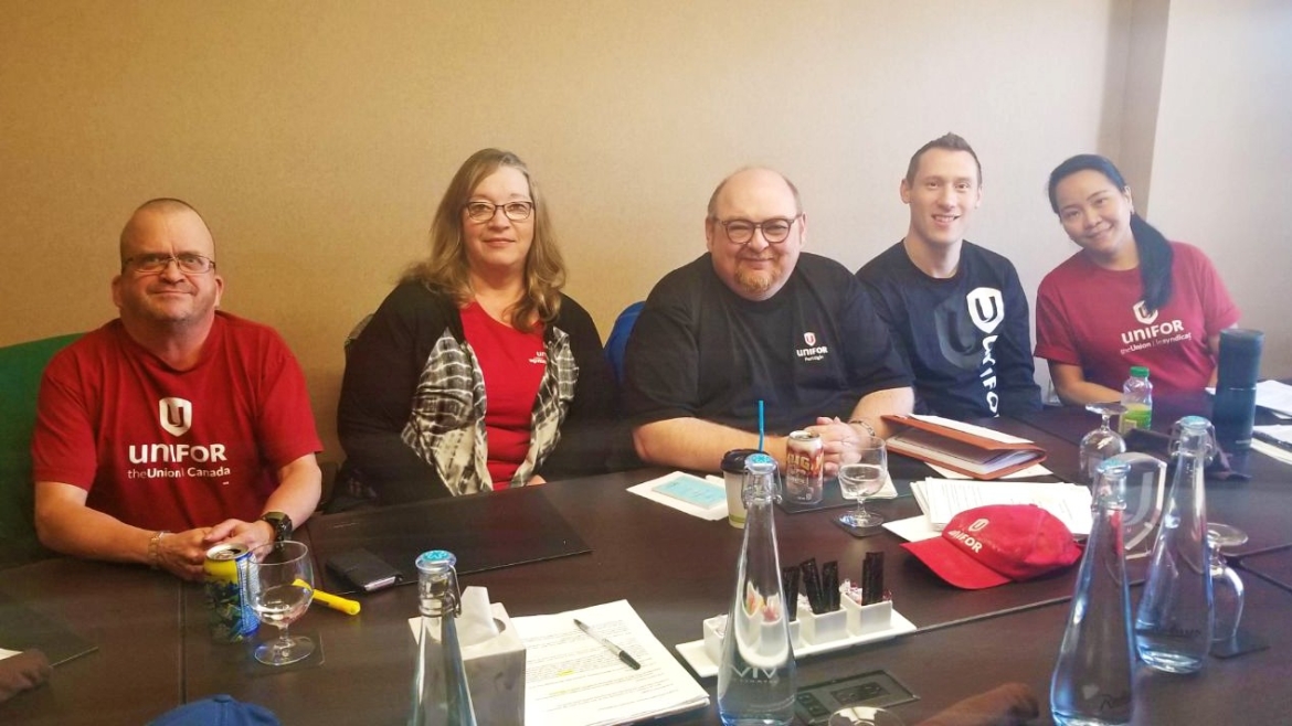 Des membres du comité de négociation de la section locale 650 de Saskatoon Radisson assis à une table de conférence.