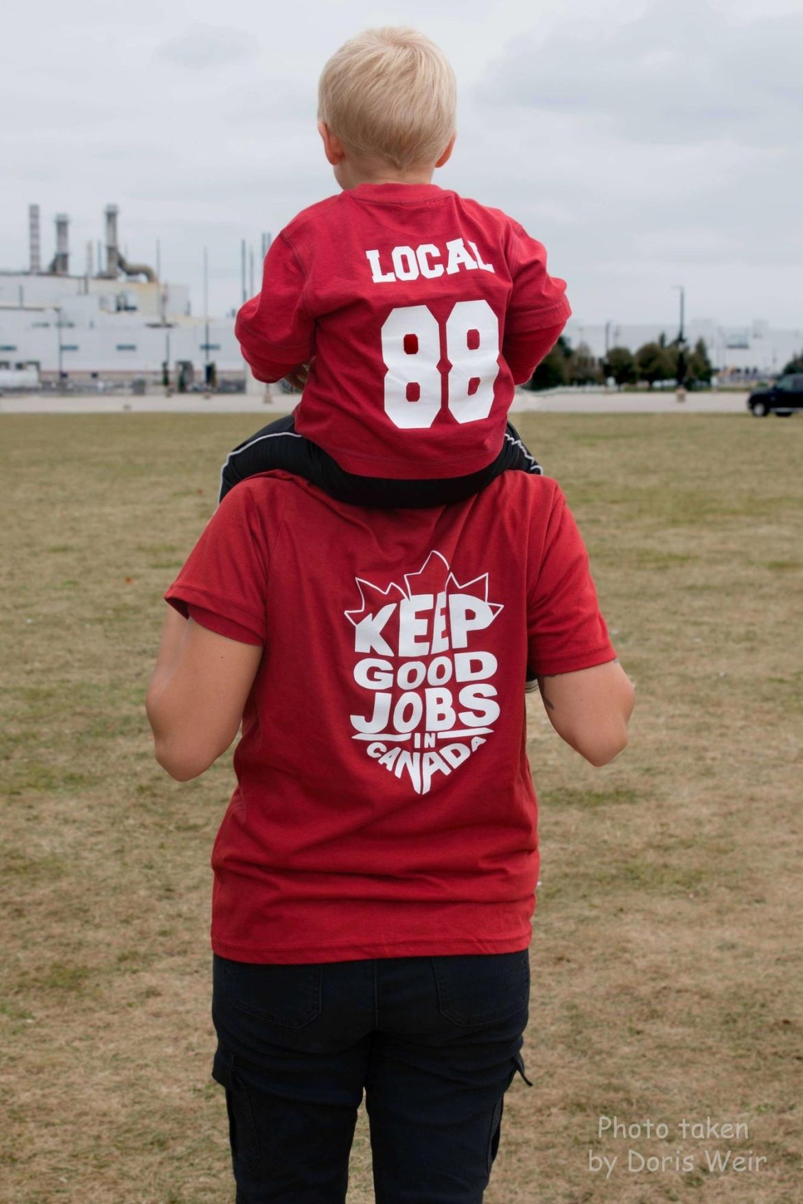 A member of Local 88 carries their child on their shoulders.