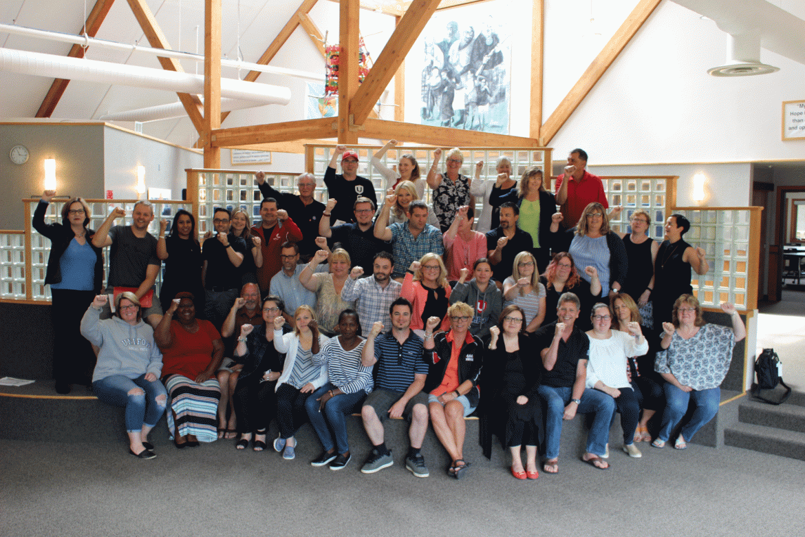 Dozens of Unifor activists at the Family Education Centre in Port Elgin raise their fists in solidarity.