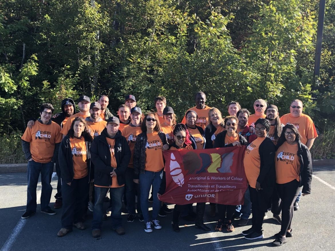 Un groupe de membres d'Unifor sourit pour une photo.