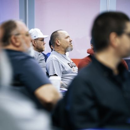 People seated listening to a someone out of frame.