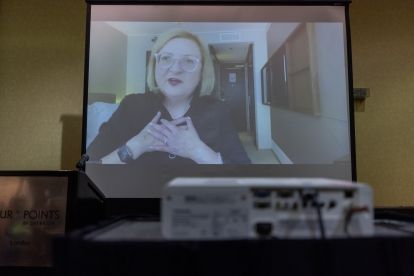 Woman on screen in meeting room