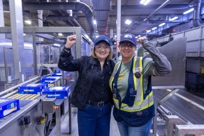 •	National President Lana Payne poses with Labett brewery worker with fists raised in air.