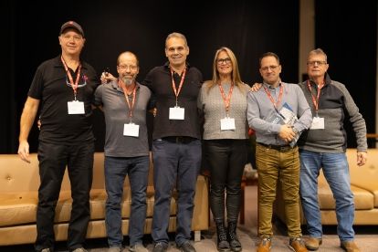 Six people standing arms linked