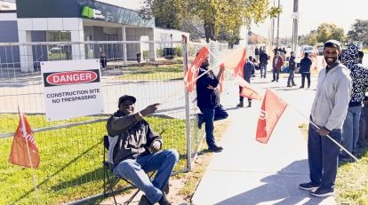 Two men holding red unifor flags smiling