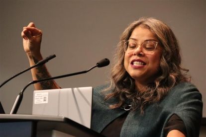 A women speaks at a mic.