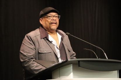 A man speaks at a mic.