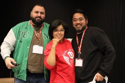 Three people posing on with their fist raised.