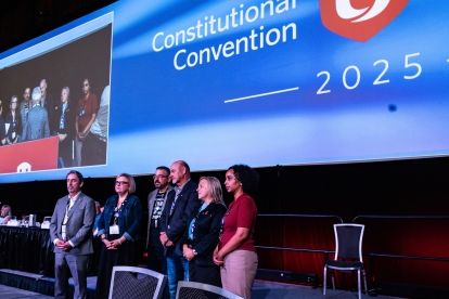 Five people on stage hands clasped