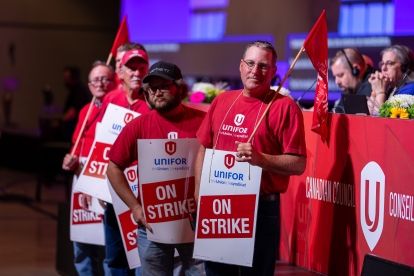 Workers holding up strike signs in front of the stage at Canadain Council