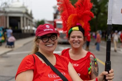 Two women in red shirts smiling