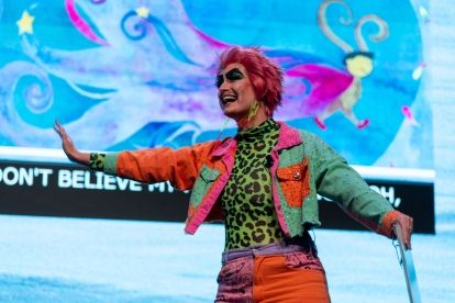 Drag story teller standing up with arm raised