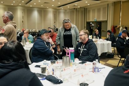 A group of people sittting at round tables in discussion