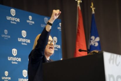 a women at a podium fist raised high in the air