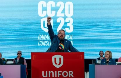 Daniel Cloutier pumping his fist inspirationally at Unifor podium