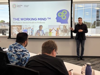 Working Mind facilitator standing in front of a presentation screen