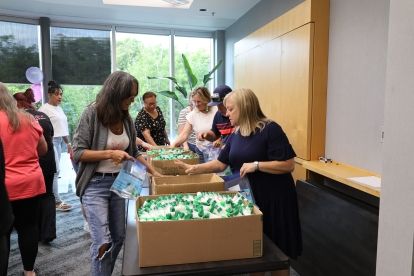 Two women looking over boxes of material