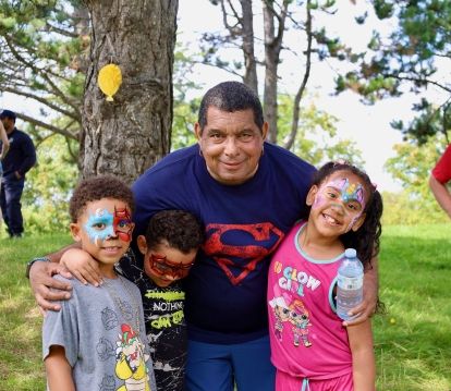 A dad poses with his three children in face paint