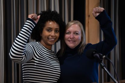 Two women smiling with their fists raised