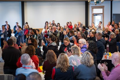 A large group standing clapping