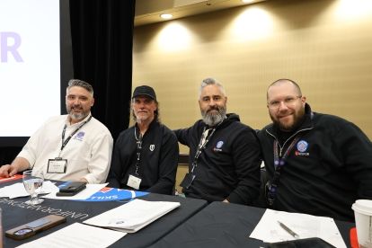 four men sitting behind a table