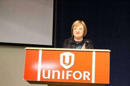 A women stands behind a Unifor podium