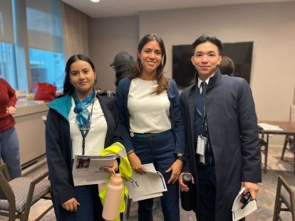 deux femmes et un homme portant des uniformes bleu marine et blanc de WestJet, posent en groupe.